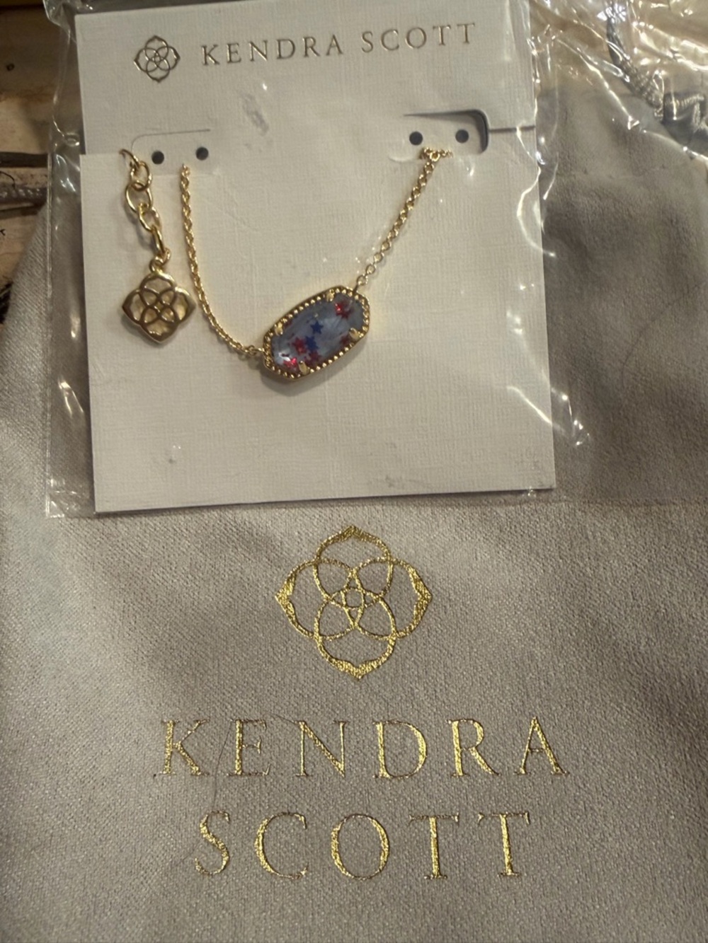 Kendra Scott Gold Necklace with Blue Oval Stone and Red Flower Accents